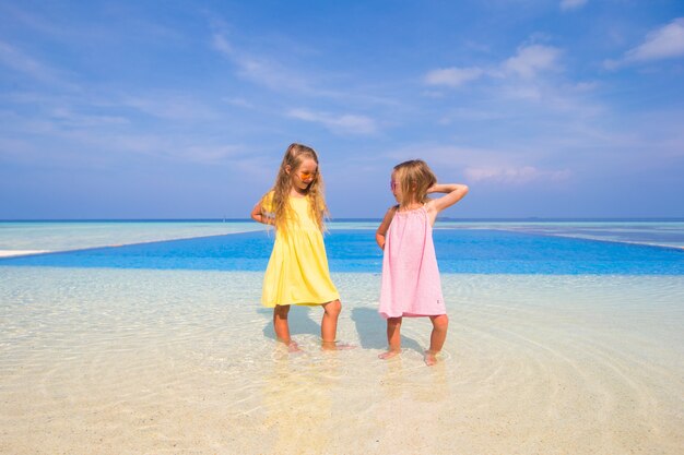 Deux petites soeurs mignonnes s'amusent ensemble près de la piscine