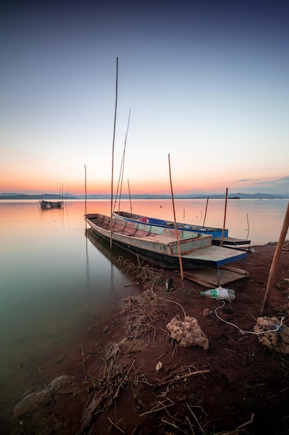 Deux petits bateaux amarrés au bord du lac. au coucher du soleil belle lumière