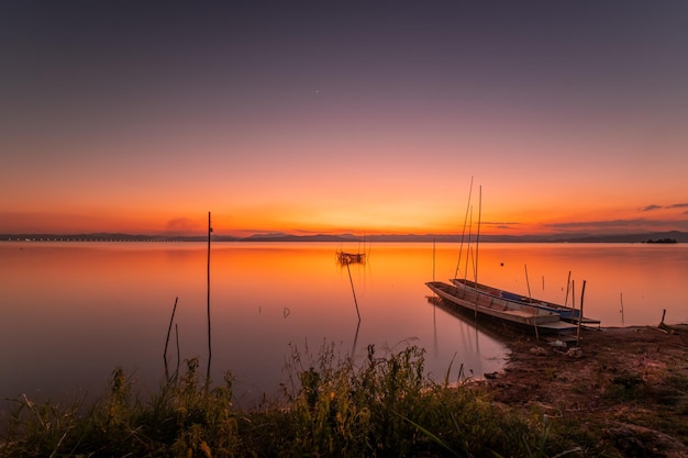 Deux petits bateaux amarrés au bord du lac. au coucher du soleil belle lumière