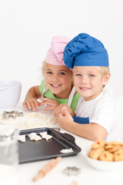 Deux petits chefs préparant des biscuits dans la cuisine