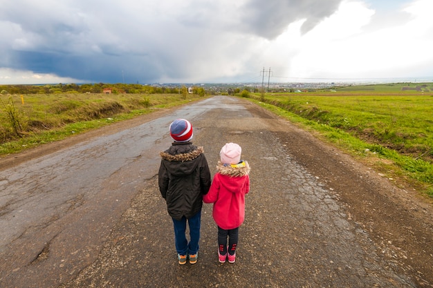 Deux Petits Enfants Garçon Et Fille Marchant Sur Une Route