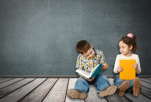 Deux petits enfants lisant en position assise