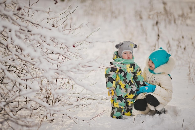 Deux petits enfants marchent dans les bois enneigés 9189