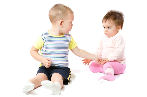 Deux petits enfants mignons assis et jouant.