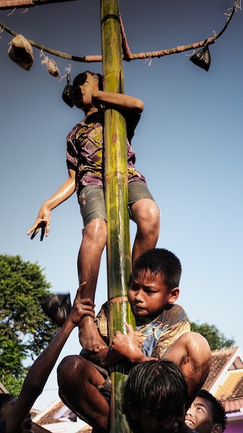 Deux petits enfants ont du mal à grimper au sommet dans le jeu Greasy Pole