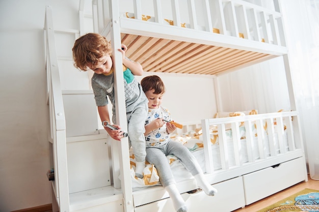 Deux petits garçons se reposent et s'amusent ensemble dans la chambre à coucher