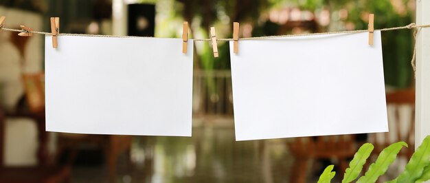 Deux photos instantanées vierges suspendues sur une corde à linge.