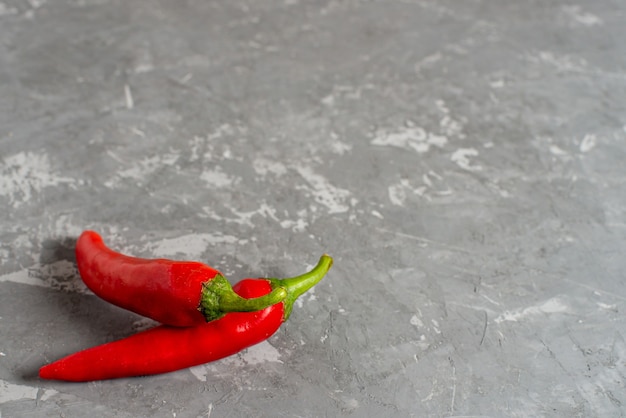 Deux piments frais sur un fond de béton, copyspace