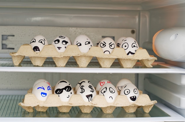 Deux Plateaux Avec Des Sourires Peints Sur Les œufs Sur Les étagères Du Réfrigérateur