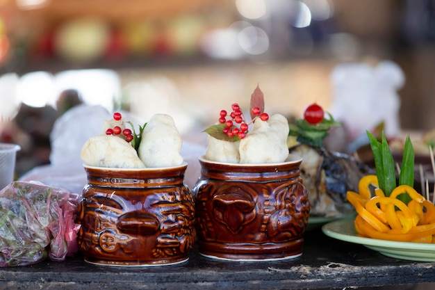 Deux pois d'argile avec de la nourriture rustiqueIl y a des pots de pommes de terre sur la table