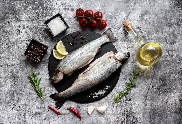 Deux poissons sur une assiette avec des ingrédients pour la cuisson.