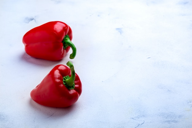 Deux poivrons rouges sur une surface blanche. vue de dessus