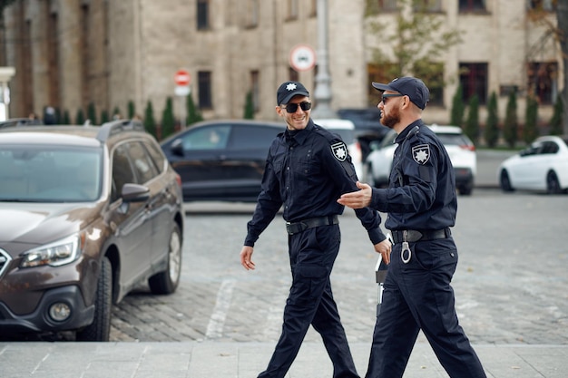 Deux policiers masculins souriants dans des lunettes de soleil