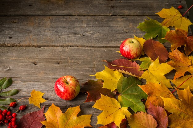 Deux Pommes Et Feuilles D'automne Sur Fond En Bois