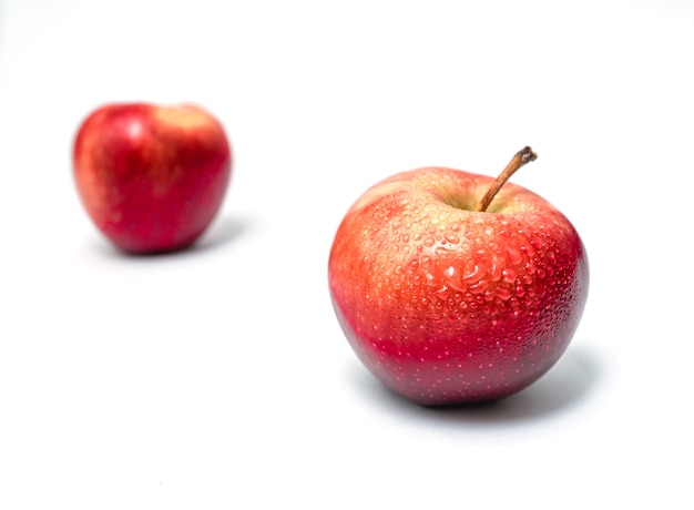 Deux pommes rouges isolées. Délicieux dessert sucré. Vue de côté. Avec des gouttes d'eau.