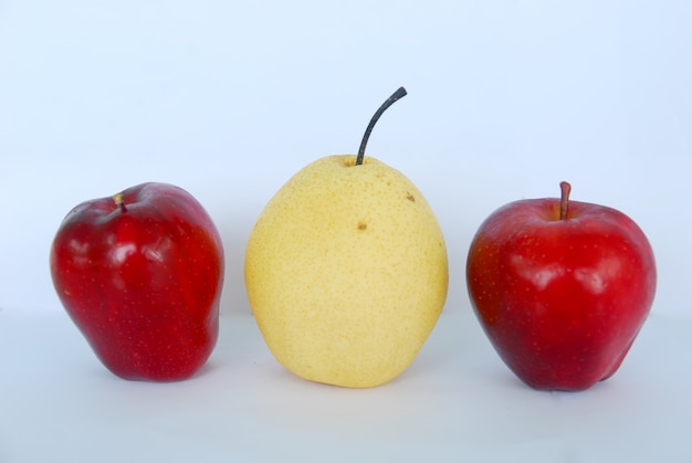 deux pommes rouges et une poire sur fond blanc