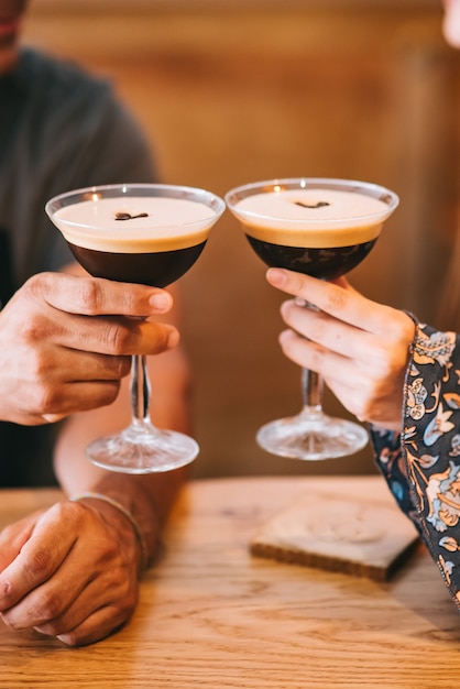 Deux portions de cocktail de café expresso dans de grands verres à martini décorés de grains de café.