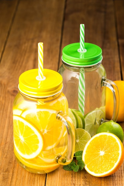 Deux pots d'eau détox avec des tranches d'orange et de citron vert