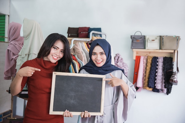 Deux propriétaires de magasins de mode asiatique avec tableau blanc