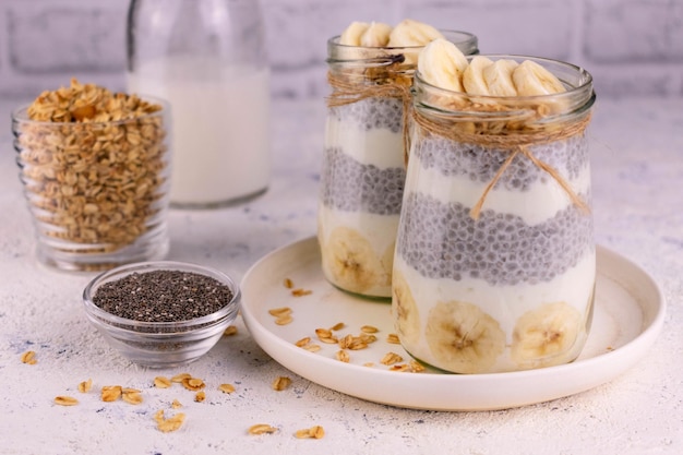 Deux puddings de chia avec banane et granola en bocaux