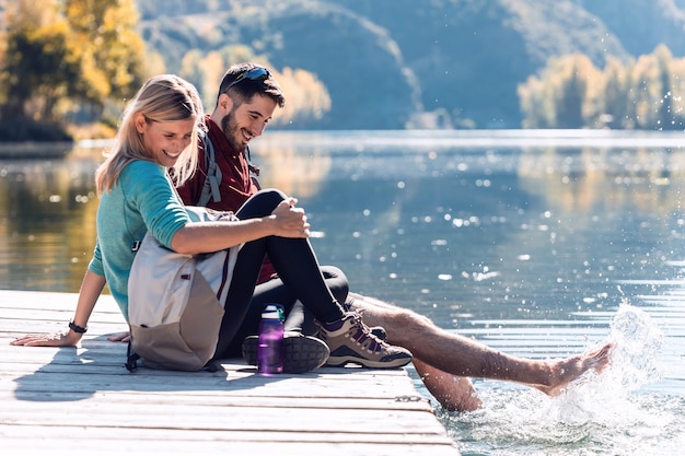 Deux randonneurs amoureux de la nature tout en jouant avec l'eau du lac de la montagne.