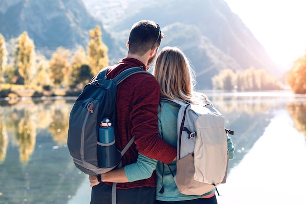 Deux randonneurs amoureux de la nature tout en regardant le paysage devant le lac en montagne.