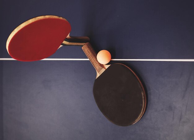 Deux raquettes de tennis et une balle sur la table de ping-pong