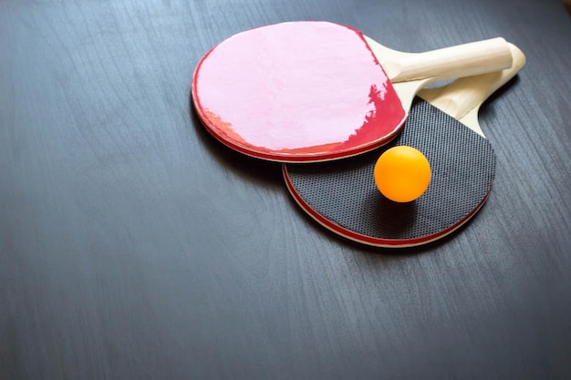 Deux raquettes de tennis de table ou de ping-pong et une balle sur fond noir