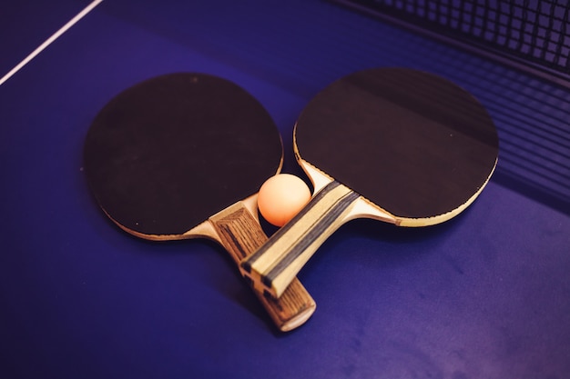 Deux raquettes de tennis de table sur table bleue