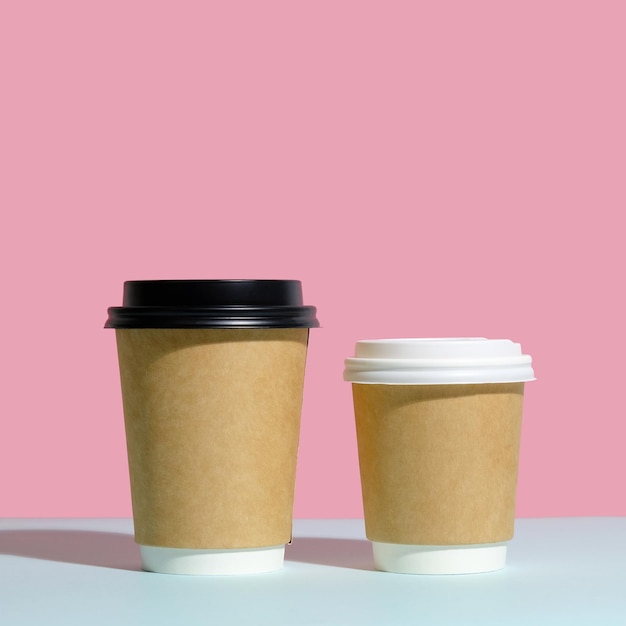 Deux récipients à café avec couvercle sur fond coloré