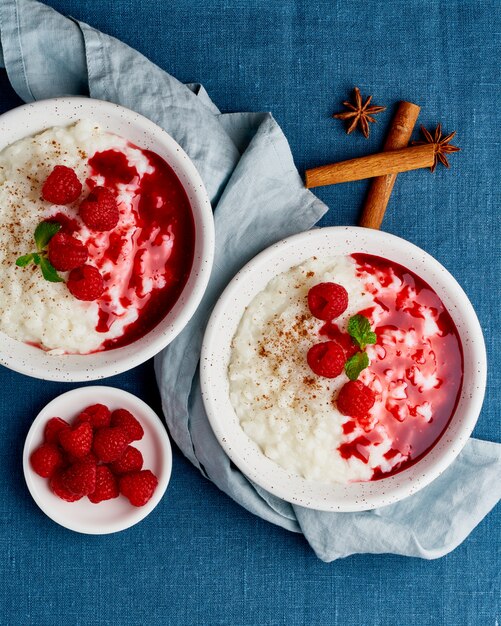 Deux riz au lait. Dessert de riz au lait français aux framboises, bleuets. Vue de dessus, verticale