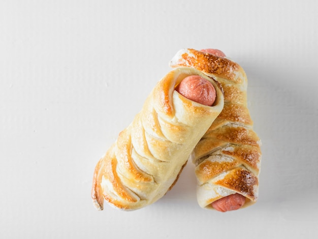 Deux rouleaux de saucisses maison sur une table en bois blanc