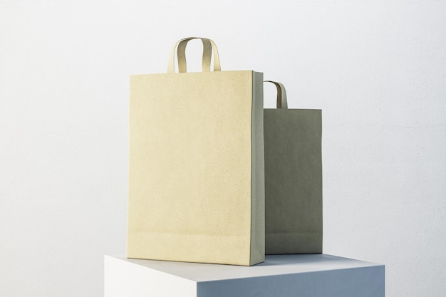 Deux sacs d'achat jaunes avec poignées sur un cube blanc Commerce et concept de cadeau Rendering 3D