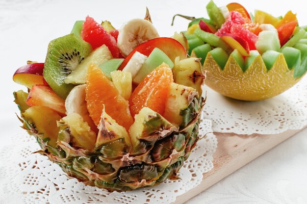 Deux salades de fruits frais avec divers fruits tropicaux dans un bol fait main de melon et d'ananas