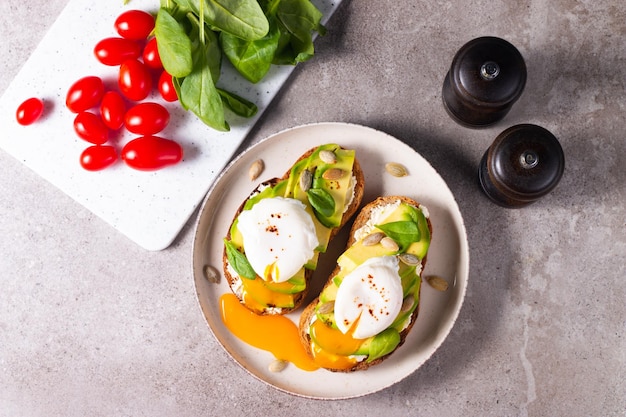 Photo deux sandwichs ouverts à l'avocat avec œuf. concept de céto et de régime. des toasts sains pour le petit-déjeuner.