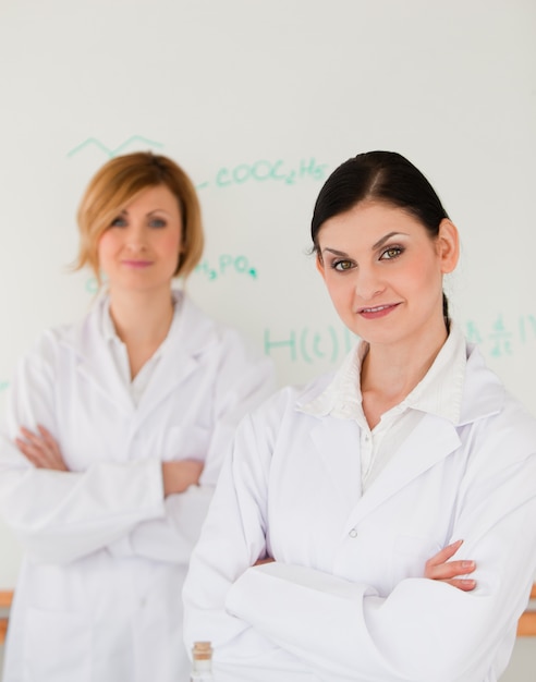 Deux scientifiques posant devant un tableau blanc