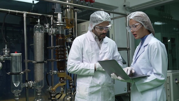 Deux scientifiques en uniforme professionnel travaillant en laboratoire