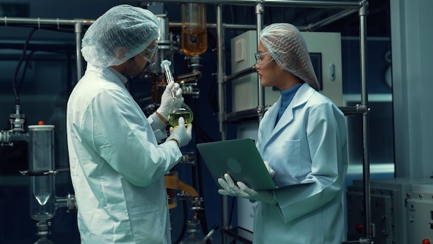 Deux scientifiques en uniforme professionnel travaillant en laboratoire