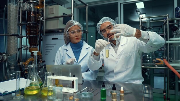 Deux scientifiques en uniforme professionnel travaillant en laboratoire