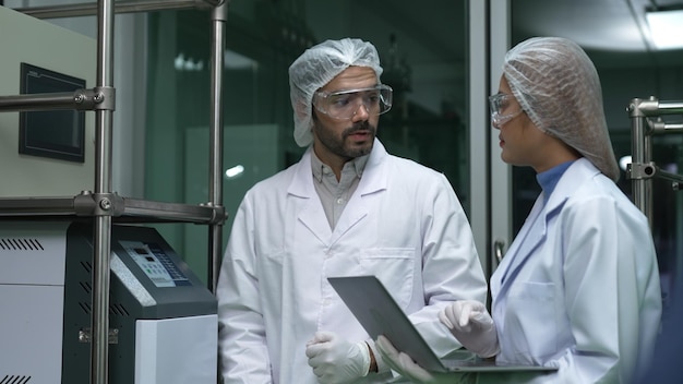 Deux scientifiques en uniforme professionnel travaillant en laboratoire