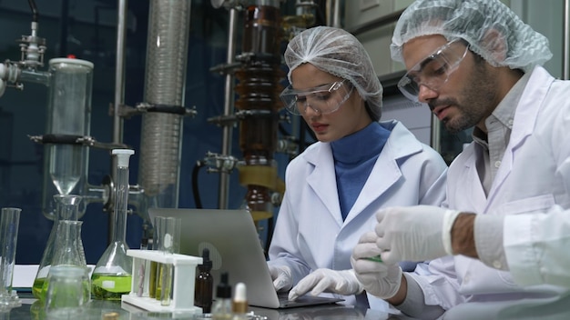 Deux scientifiques en uniforme professionnel travaillant en laboratoire