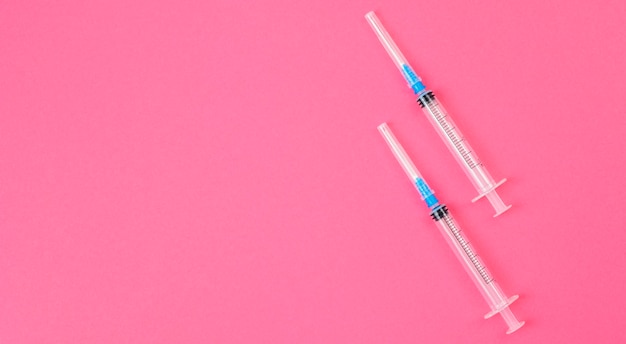 Deux Seringues Sur Fond Rose. Concept De Vaccin Et D'injections Contre Le Coronavirus.