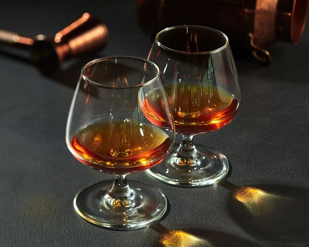 Deux snifters avec du cognac sur un comptoir en pierre gris foncé