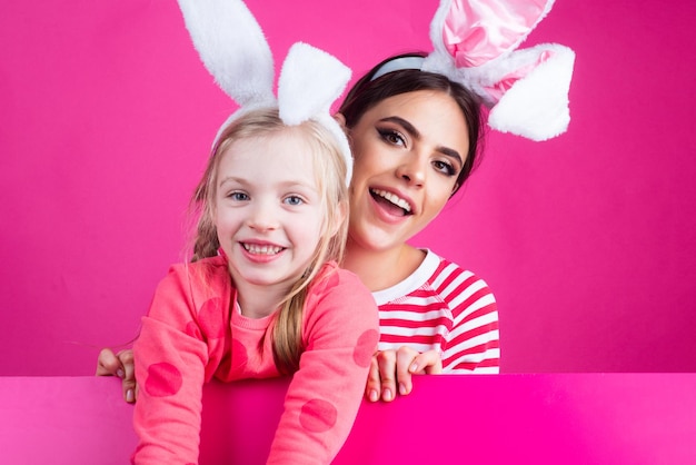 Deux sœurs chassant les œufs de Pâques. Filles avec des oreilles de lapin. Vacances de printemps.