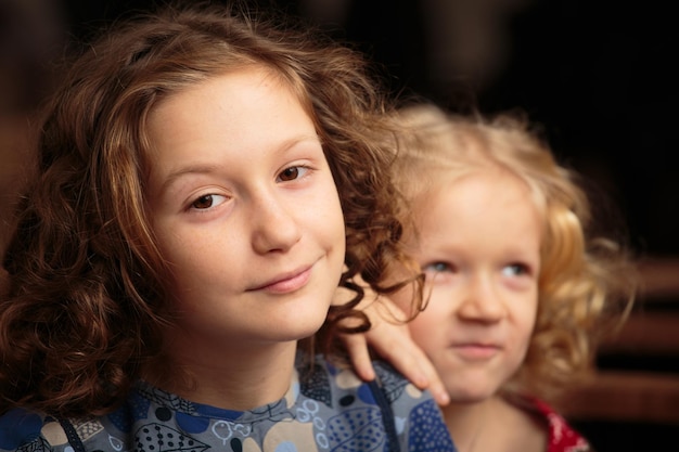 Deux sœurs enfants souriantes regardent la caméraxA