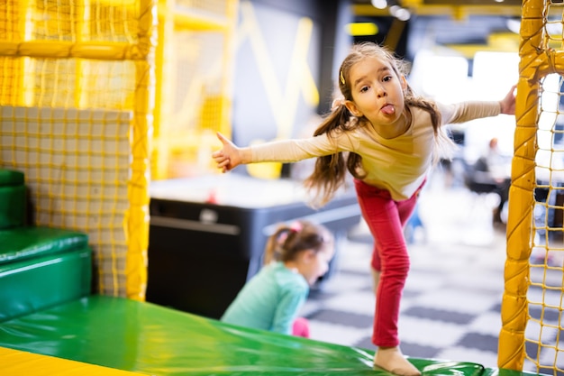 Deux sœurs jouant au centre de jeux pour enfants Funny girl show tongue