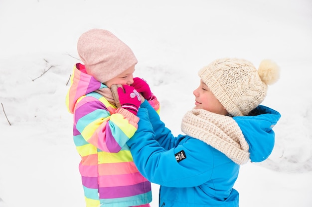 Deux sœurs jouent mignonnes dehors un jour d'hiver