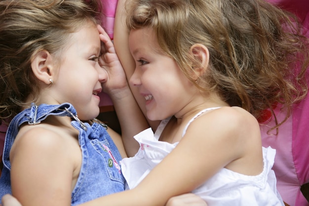 Photo deux soeurs jumelles dans un câlin, gros plan