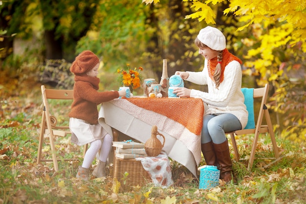 Deux soeurs mignonnes sur pique-nique en automne parc. Adorables petites filles ayant un goûter à l'extérieur dans le jardin d'automne. Saisonnier