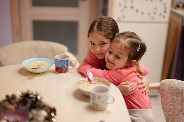 Deux sœurs s'embrassent et dînent ensemble dans la cuisine